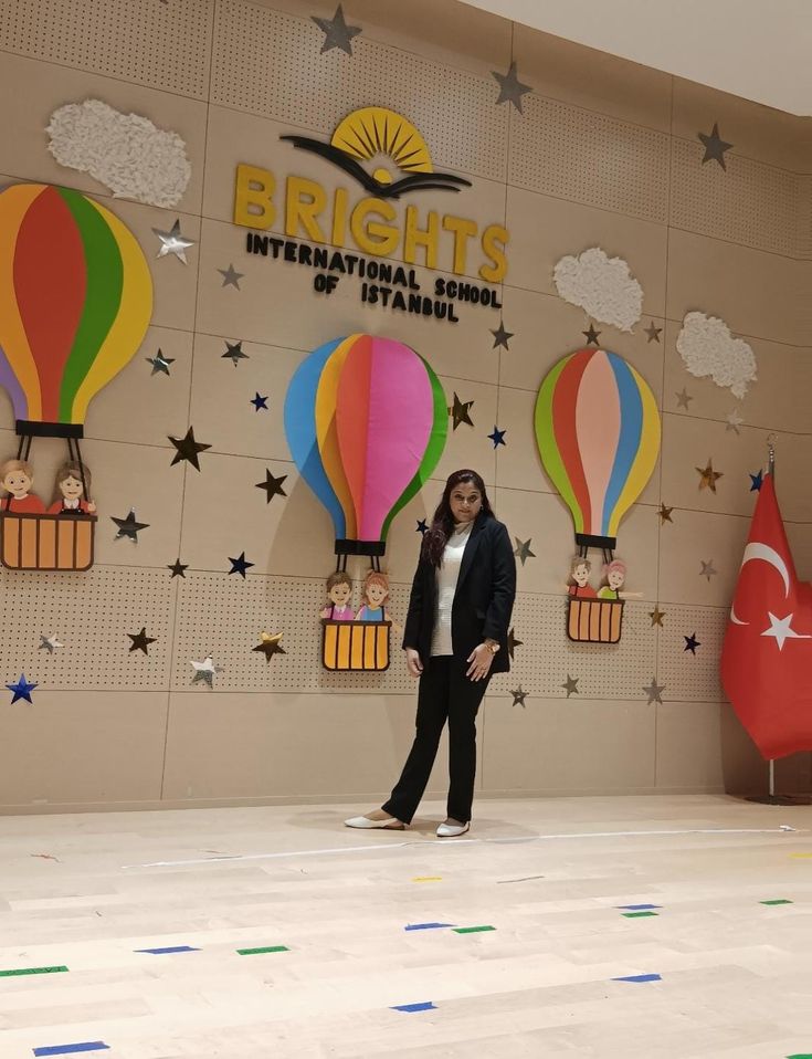 a woman standing in front of a wall with hot air balloons on it