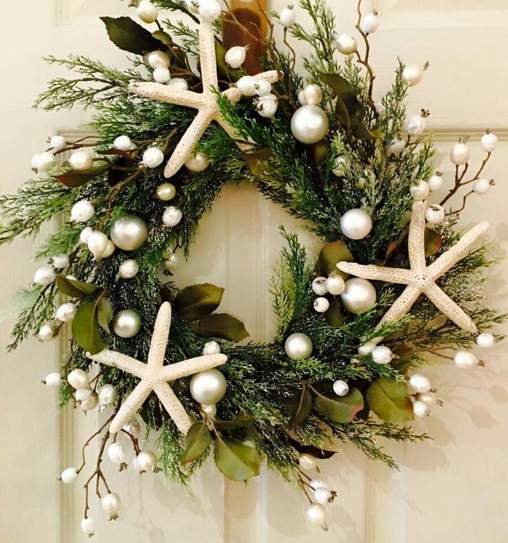 a christmas wreath with starfishs and greenery