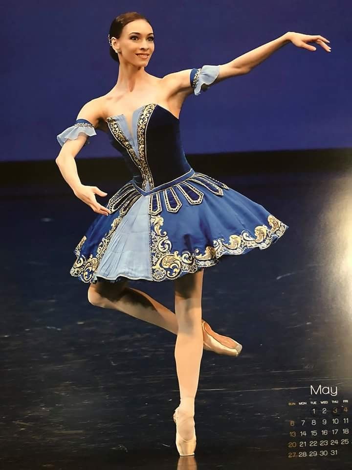 a woman in a blue and black dress is dancing