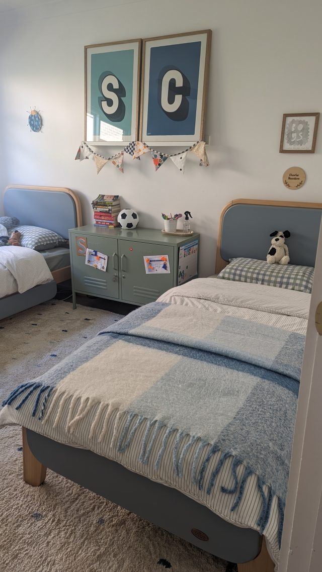 a bedroom with two twin beds and soccer themed decor on the wall above them is also a dresser