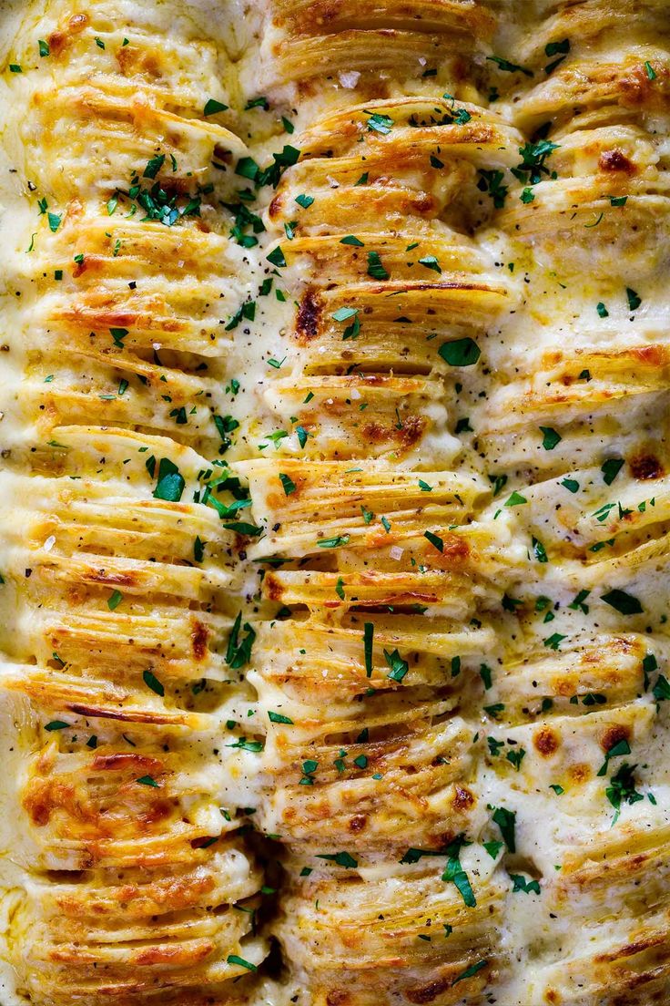 baked potato casserole with parmesan cheese and herbs on top, ready to be eaten