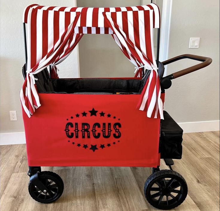 a red and white circus wagon with black wheels