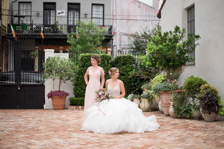 two brides standing in front of some potted plants