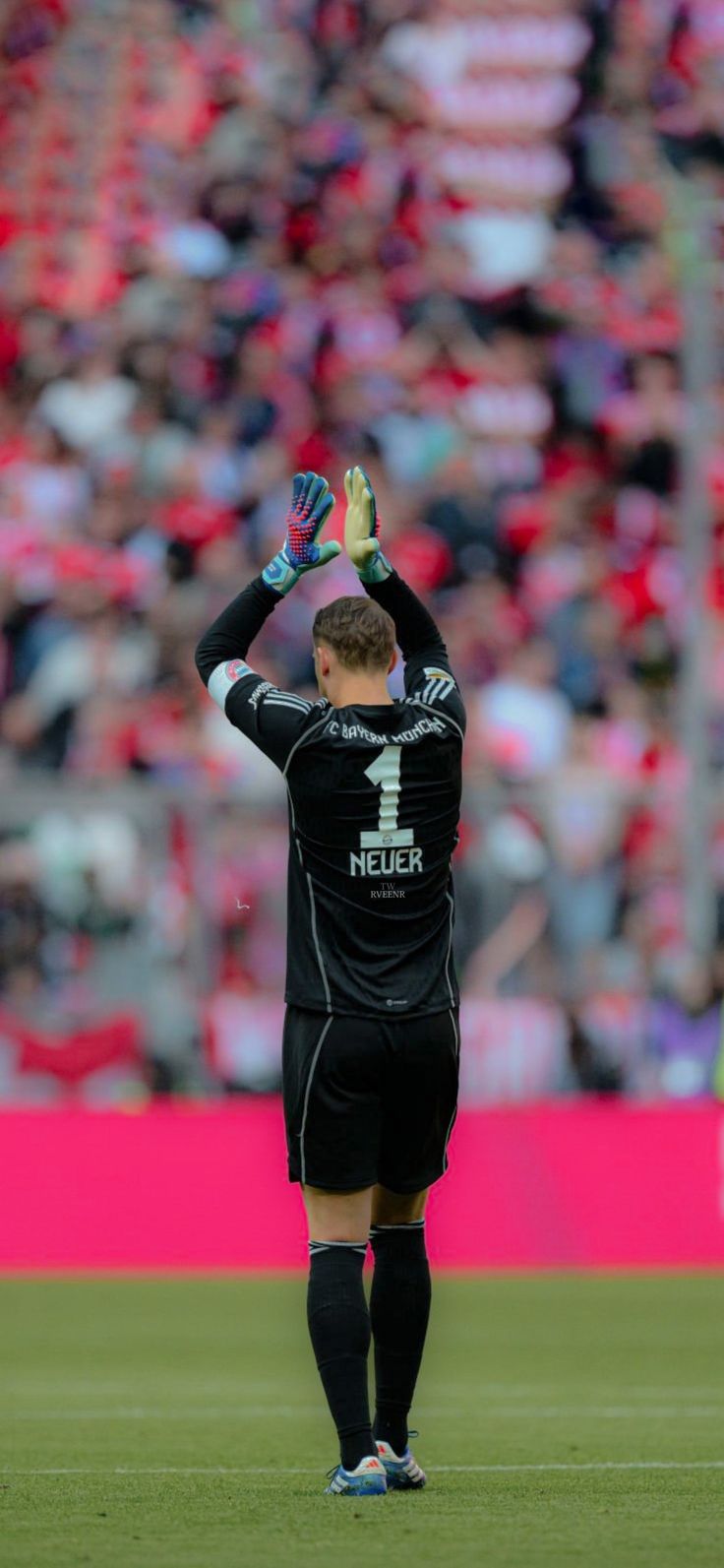 a soccer player holding his hands up in the air