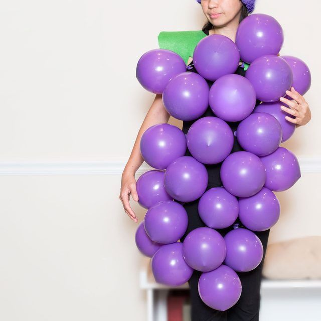 a woman holding a bunch of purple balloons