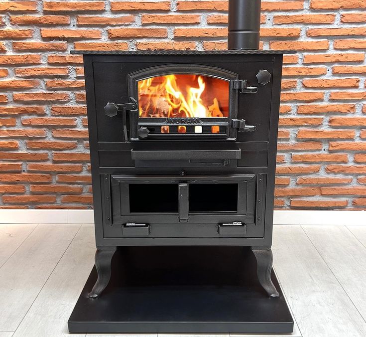 a black stove sitting in front of a brick wall