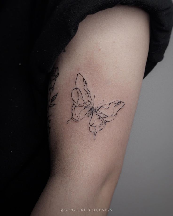 a woman's arm with a butterfly tattoo on it