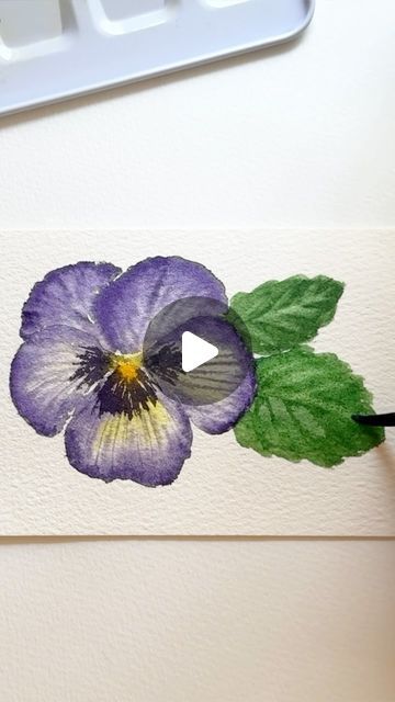 a watercolor painting of a purple flower on a white paper with green leaves and a black marker