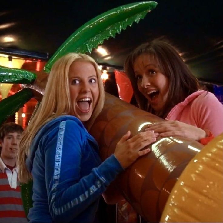 two girls are standing next to each other in an amusement park