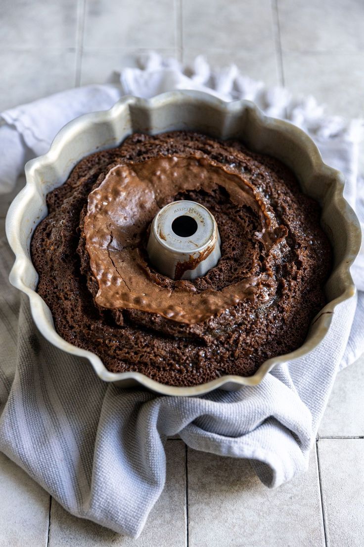 a cake in a pan with chocolate frosting on top and a napkin next to it