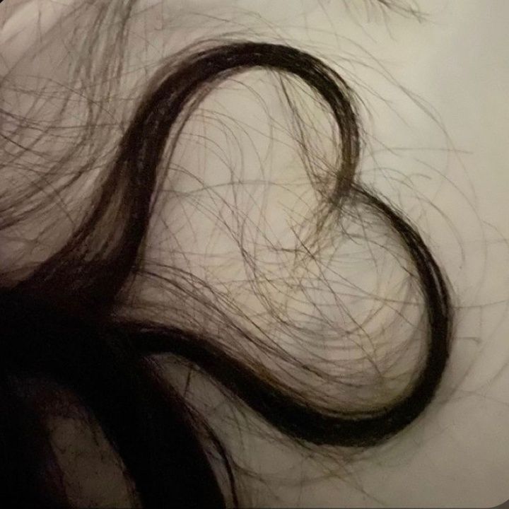 the hair is laying on top of the white sheet with scissors in it's hand