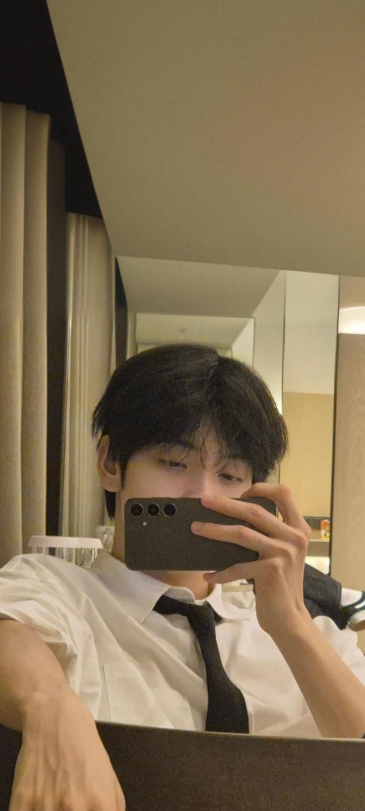 a man taking a selfie in front of a mirror with his cell phone up to his face