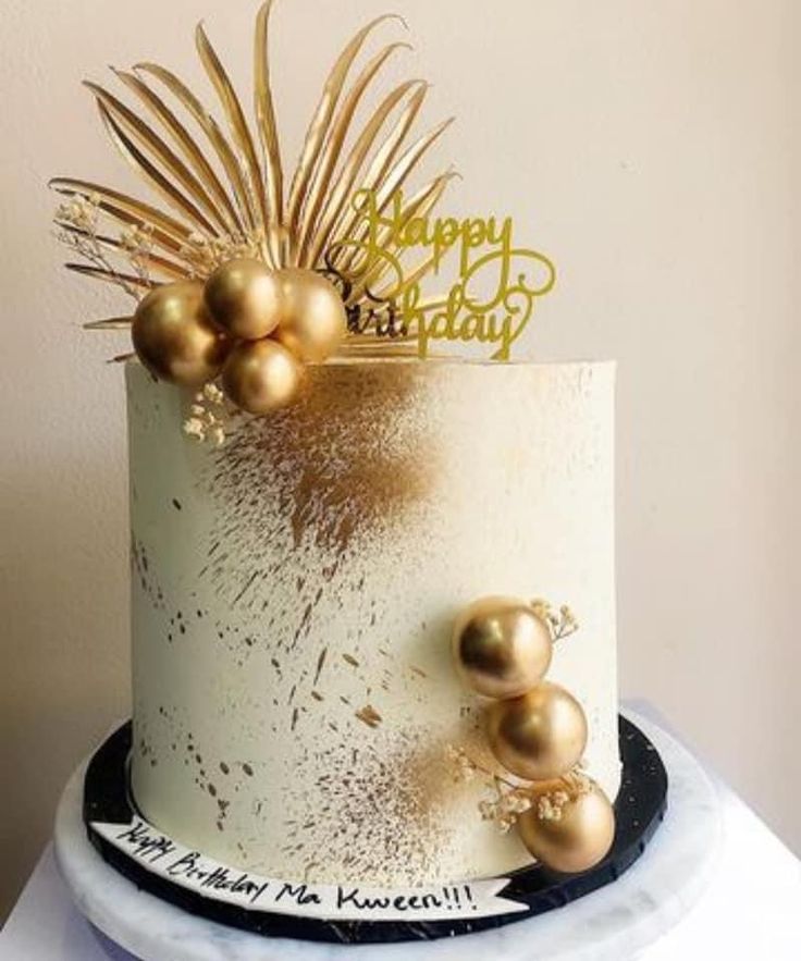 a birthday cake with gold decorations on top