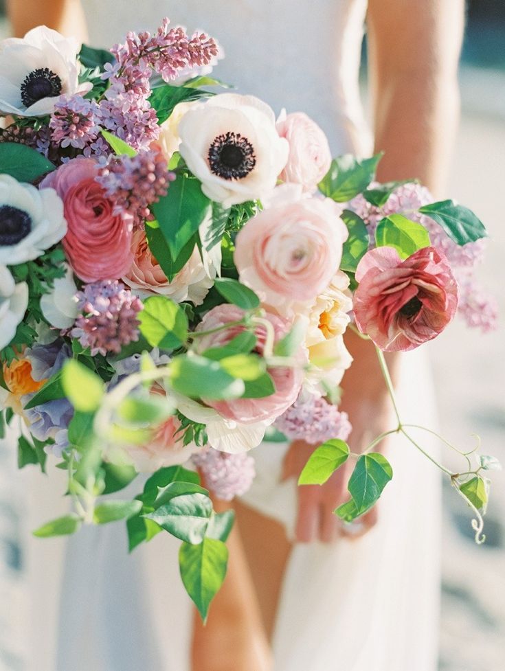 a bride holding a bouquet of flowers in her hands