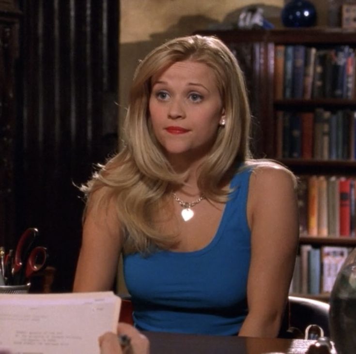 a woman sitting at a table in front of a book