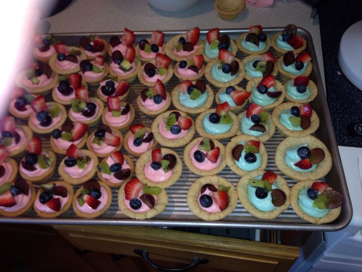 a pan filled with cupcakes covered in fruit