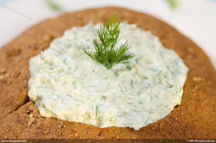 a cracker topped with cream cheese and a sprig of dill