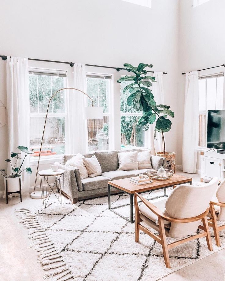 a living room filled with furniture and large windows