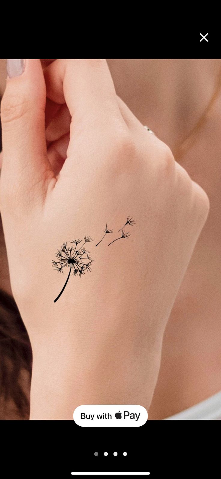 a woman's wrist with a dandelion tattoo on the left side of her arm