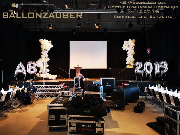 a stage set up for an event with balloons in the shape of letters and numbers