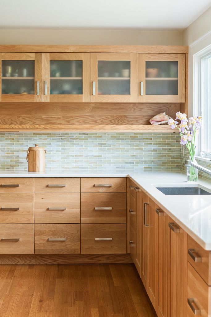 a kitchen with wooden cabinets and white counter tops