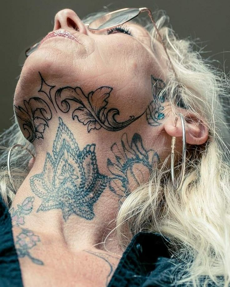 a woman with tattoos on her face and neck