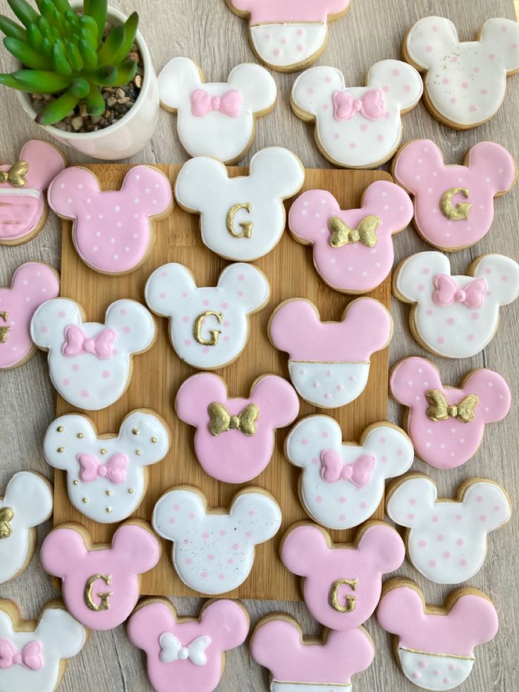 decorated cookies are arranged in the shape of mickey and minnie mouse ears on a wooden board