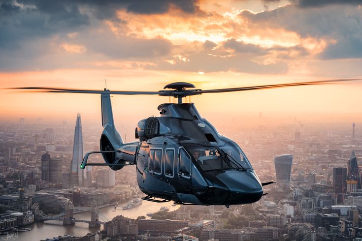 a helicopter flying over a city at sunset