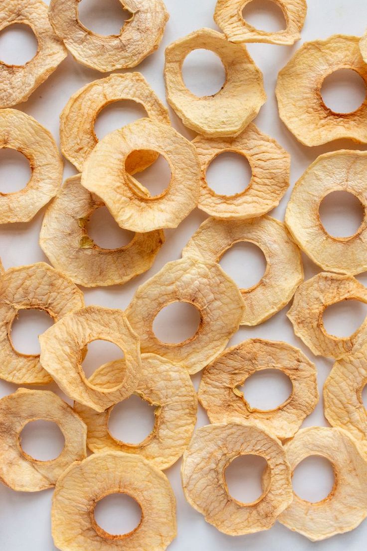 several pieces of potato chips on a white surface with holes cut in half to look like rings