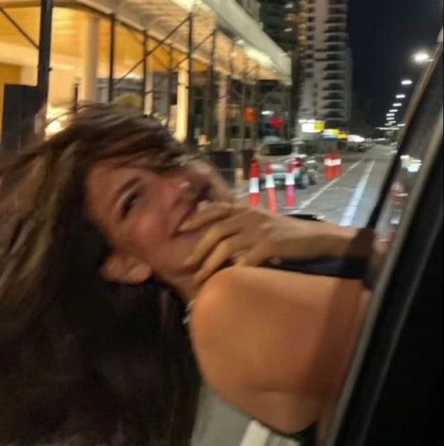 a woman leaning on a rail in the city at night