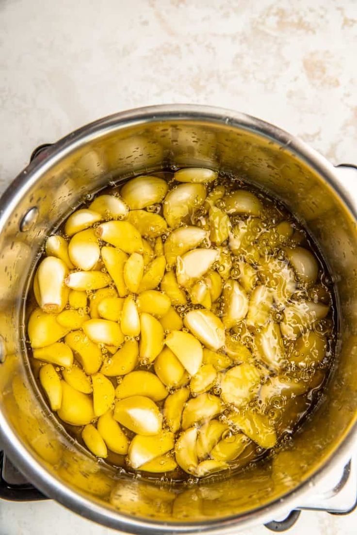 a pot filled with cooked garlic on top of a stove next to the words, how to make stocktop garlic confit