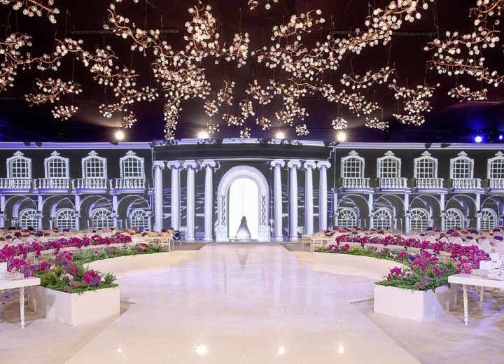 a large room with tables and flowers on the floor in front of an entrance to a building