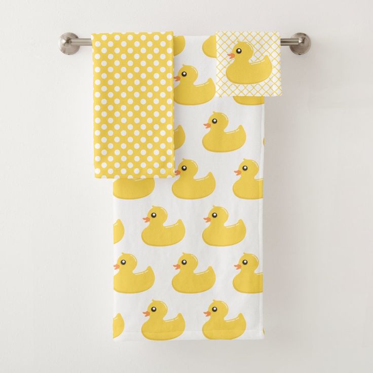 two yellow rubber ducky bath towels hanging on a towel rack