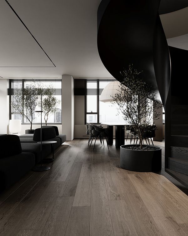 a living room with wood floors and black furniture