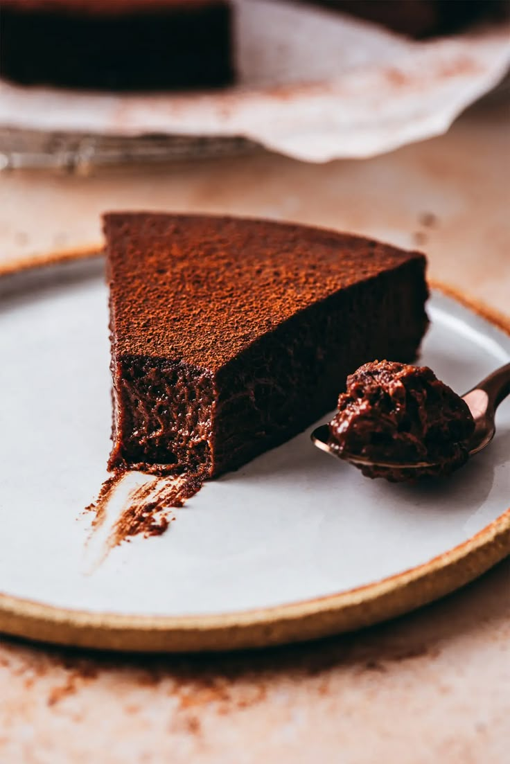 a piece of chocolate cake on a plate with a spoon