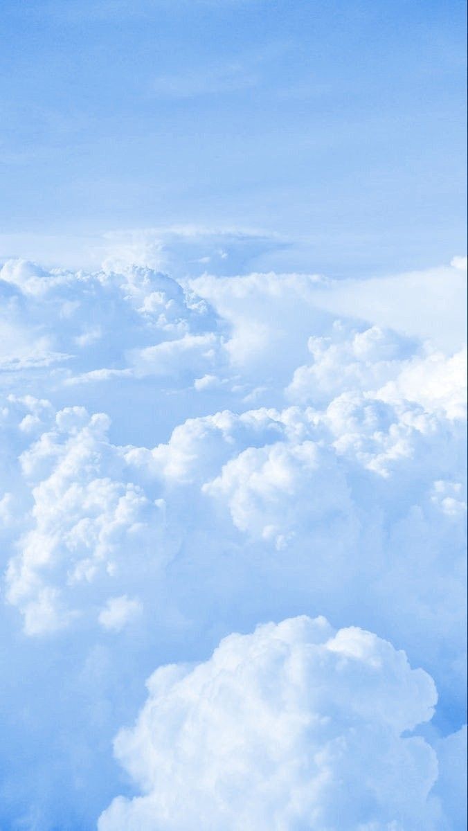 an airplane is flying high in the sky above some fluffy white clouds and blue skies