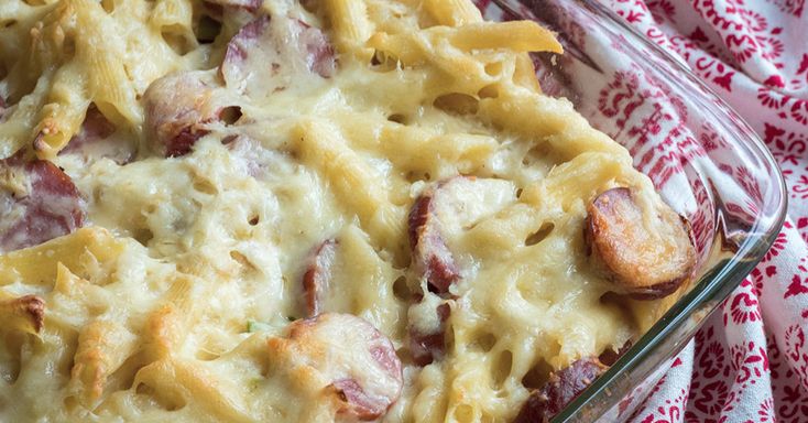 a casserole dish with ham and cheese in it on a red and white cloth