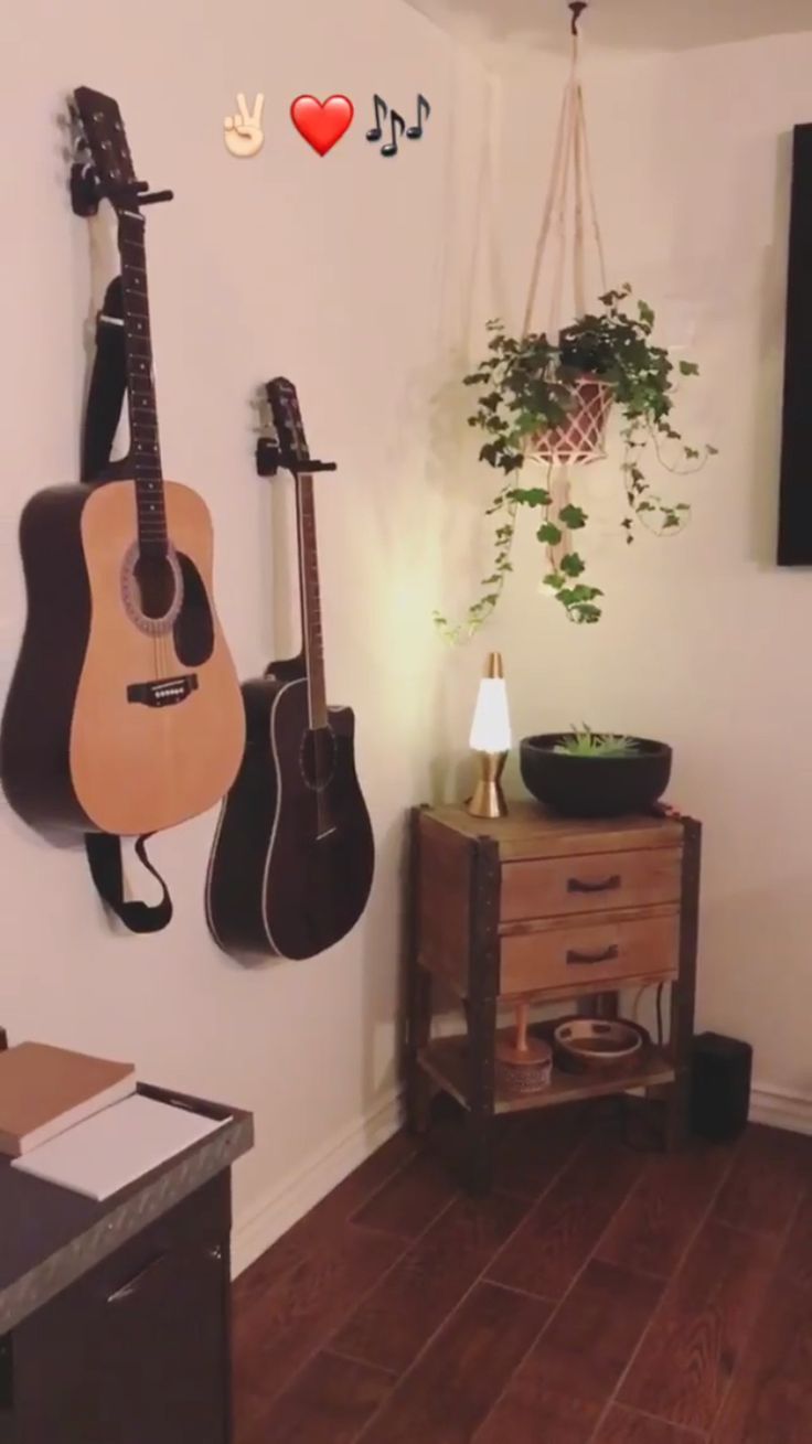 there is a guitar hanging on the wall next to a potted plant and other musical instruments