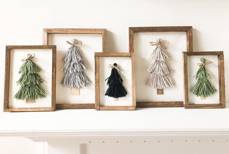 three framed pictures with tassels hanging from them, one is green and the other is white