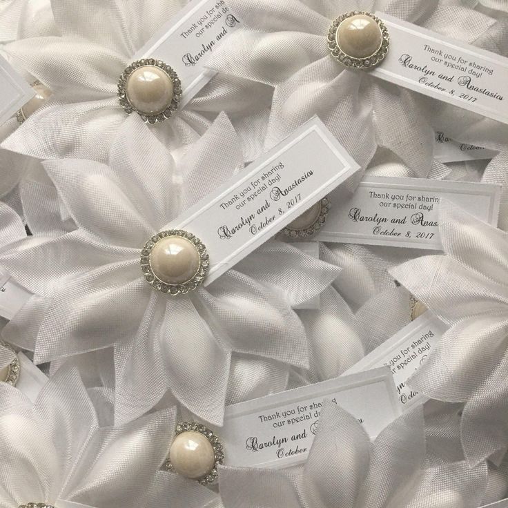 some white ribbons with pearls and tags on them