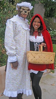 two people dressed up in costumes posing for a photo with one holding a basket and the other wearing a mask