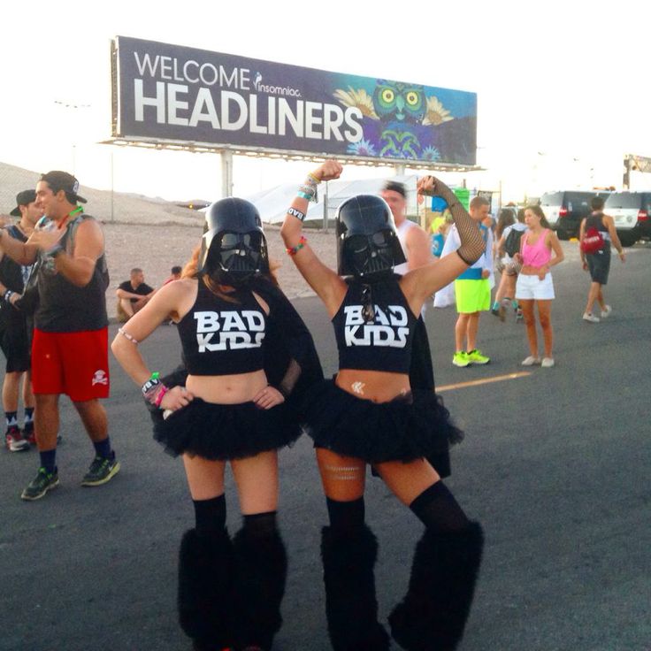 two women dressed in costumes are standing on the street with their arms around each other