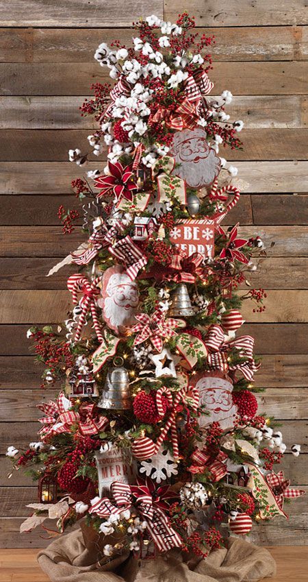 a christmas tree decorated with red, white and silver ornaments on top of a wooden table