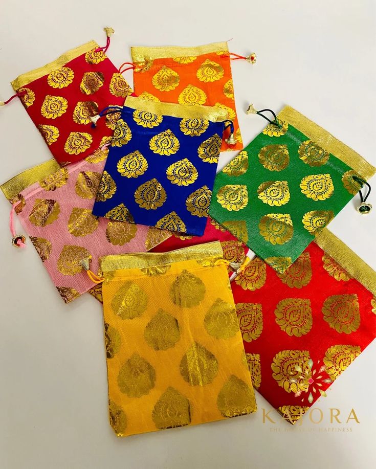 five different colored bags with gold designs on them