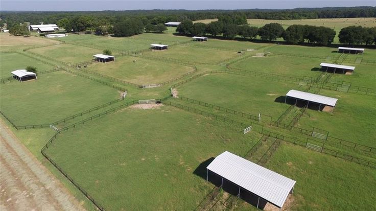 an aerial view of several farm buildings in the middle of a field