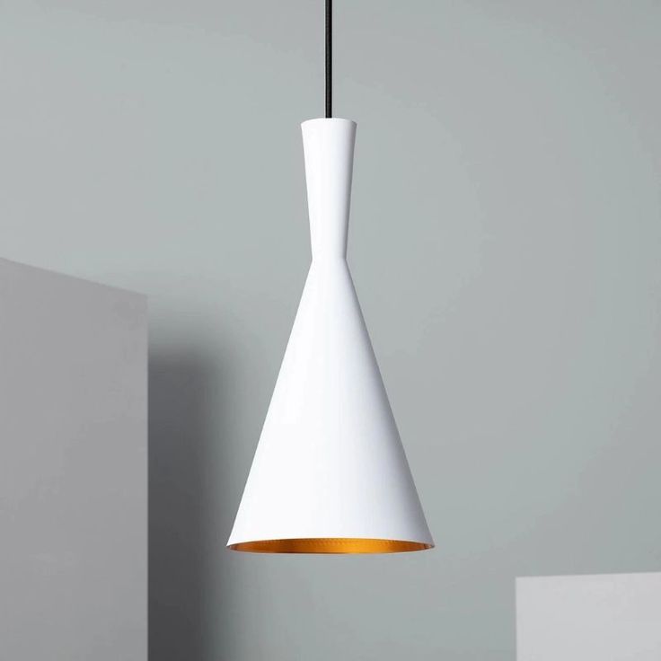 a white and gold colored light hanging from a ceiling fixture in a room with grey walls