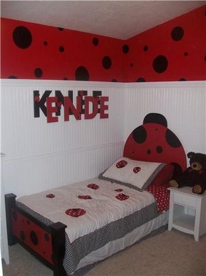 a child's bedroom decorated in red and black with ladybugs on the wall