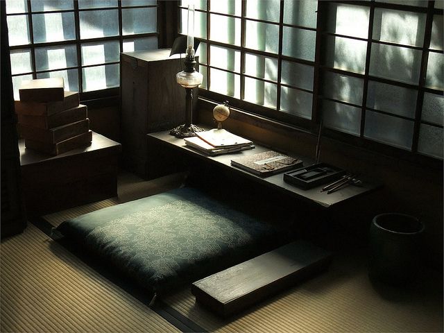 an empty room with tatami mats and windows