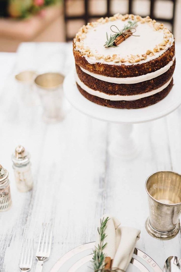 a cake sitting on top of a white table next to silverware and cups with napkins