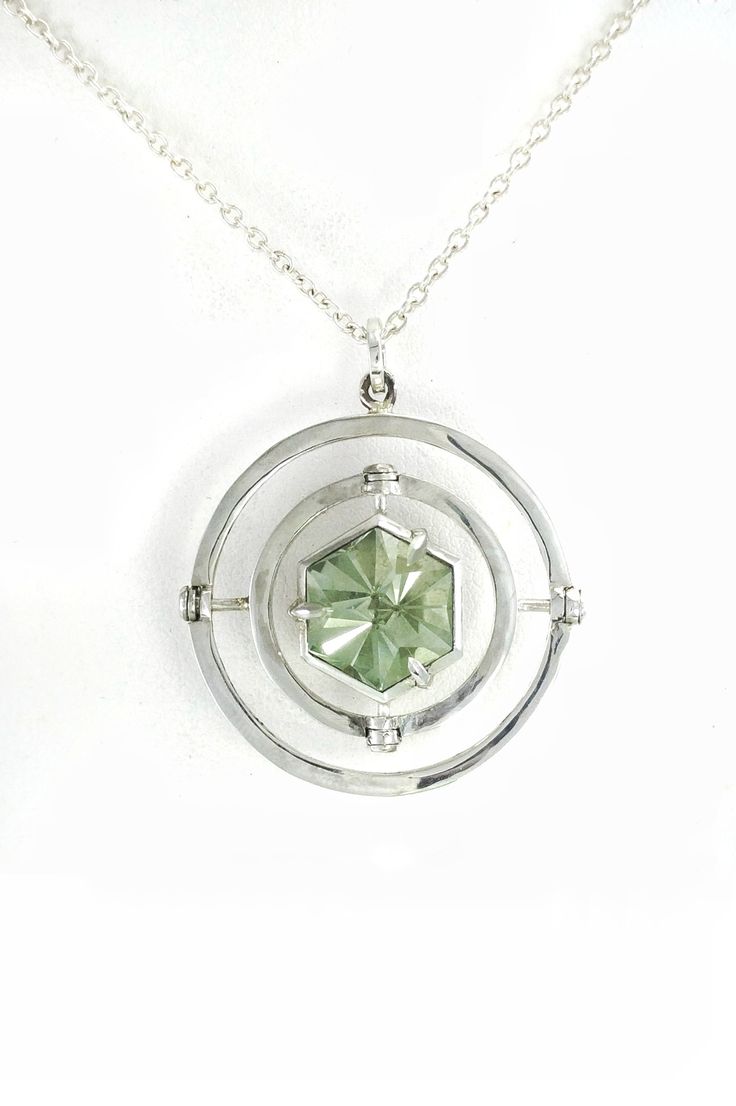 A one of a kind kinetic pendant of sterling silver, prasiolite and gray spinel. By Phetteplace Studio    #handmade #prasiolite #kinetic #grayspinel #spinel #geometric #artdeco #pendant #ooak #mint #green #jewelry #necklace #moving #gyroscope #armillary #phetteplacestudio Modern Jewelry With Rotating Bezel For Gift, Sterling Silver Jewelry With Diamond Cut In Octagon Shape, Faceted Sterling Silver Gemstones For Formal Occasions, Octagon Sterling Silver Jewelry With Diamond Cut, Octagon Shaped Diamond Cut Sterling Silver Jewelry, Kinetic Jewelry Green Tree Jewelry, Octagon Sterling Silver Jewelry With Bezel Setting, Silver Spiral Gemstone Jewelry, Octagon-shaped Sterling Silver Jewelry With Diamond Cut